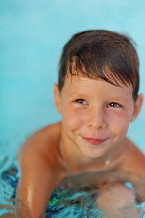 hot summer day, the boy fun dives and swims in the poolの写真素材