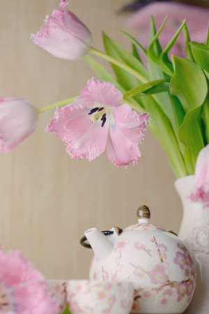 festive still life on a light background pink tulips and tea service