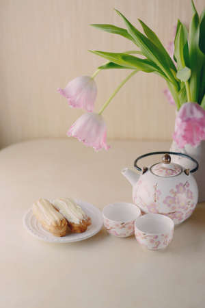 festive still life on a light background pink tulips and tea service