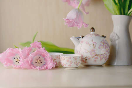 festive still life on a light background pink tulips and tea serviceの写真素材