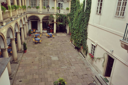 old courtyard with arches and white house with green ivy