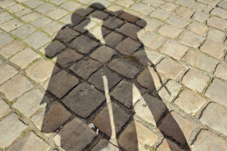 closeup cobblestone road with shadow of a couple of peopleの写真素材