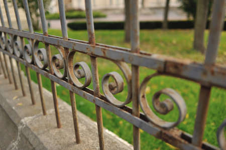 in the park in the foreground an old rusty metal fenceの写真素材