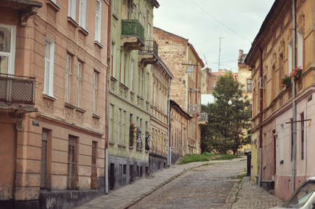 Street with old houses with large windows and brick sidewalk