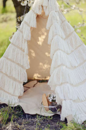 in the lush garden elegant white tent and a basket of bread and flowers