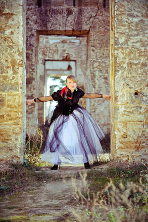 girl posing in lush white skirt a collapsed building near the oldの写真素材