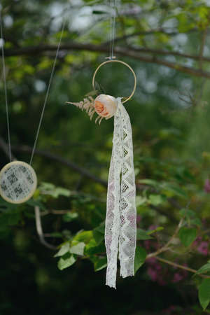 in the park on the green branches of trees beautiful floral arrangement with ring and ribbonの写真素材