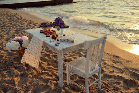 sunrise on the beach in the sand is a table with color and peachesの写真素材