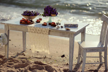 sunrise on the beach in the sand is a table with color and peachesの写真素材