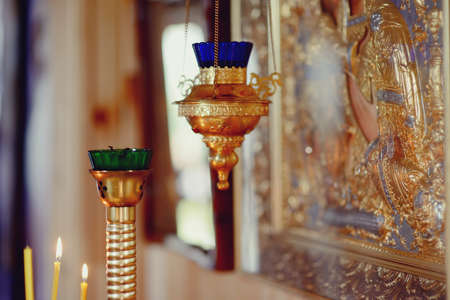 in the church in gold icons with oil lamps candlesticks with candles