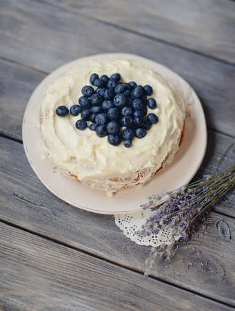 pie on a wooden table decorated with berries and lavender bouquet の写真素材