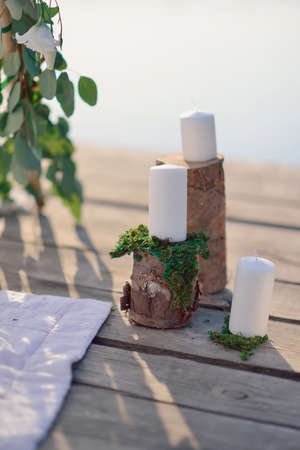 on a wooden bridge in the sun romantic arrangement of candles, glass and stumpsの写真素材