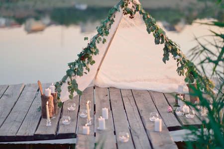 the river on a wooden bridge white tent and burning candlesの写真素材