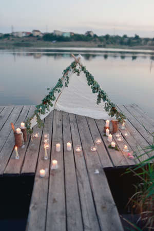 the river on a wooden bridge white tent and burning candlesの写真素材