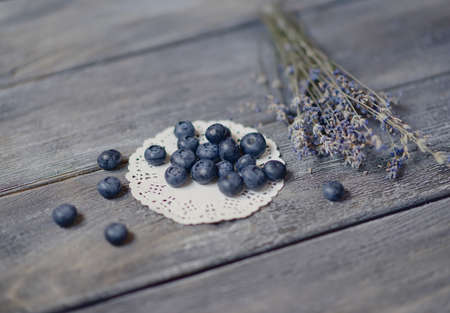 on a wooden table on a white napkin is blueberries and lavender bouquetの写真素材
