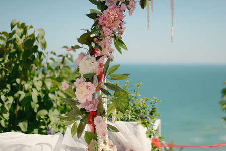 floral wedding arch against the blue sky and seaの写真素材