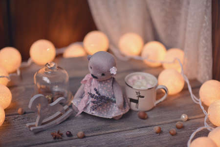 on wooden table lit candle and garland and a wooden horse and bearの写真素材