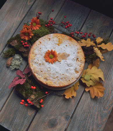 pie on a wooden surface on the leaves and moss with flowersの写真素材