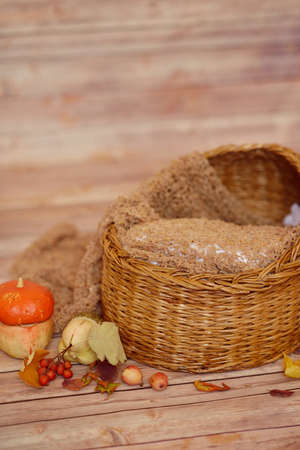 on the wooden floor wicker basket and decorative pumpkinの写真素材