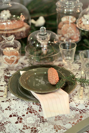 Christmas table setting in a rustic style with green plates and napkins traceryの写真素材