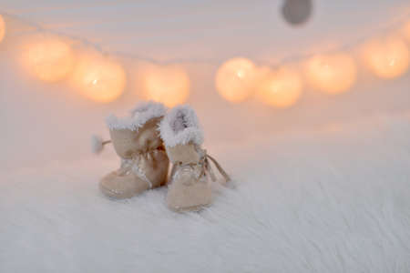 lit garland baby fur boots on light backgroundの写真素材