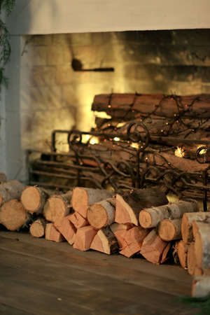 lit a large fireplace with wood burning and garlandの写真素材