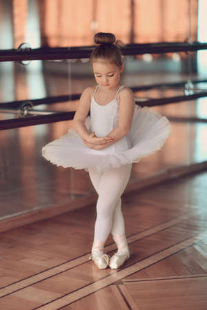 in the hall near the large mirrors dancing little ballerina in white tutuの写真素材