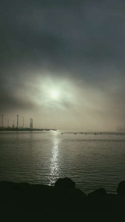 on the horizon over the sea sunset in dense cloudsの写真素材
