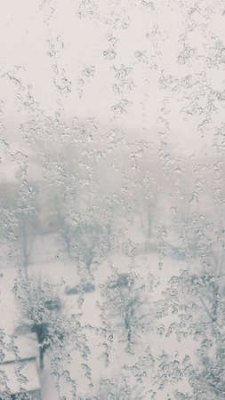 background winter window frost melts and runs down the glassの写真素材