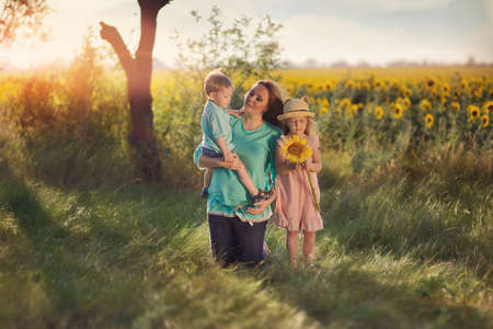 in the forest in a clearing in the sunlight plays a mother with childrenの写真素材