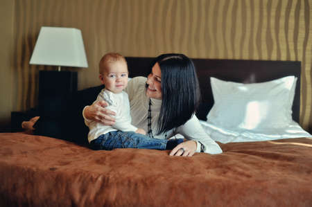 on the bed in the room sitting small son with red hair with her mother