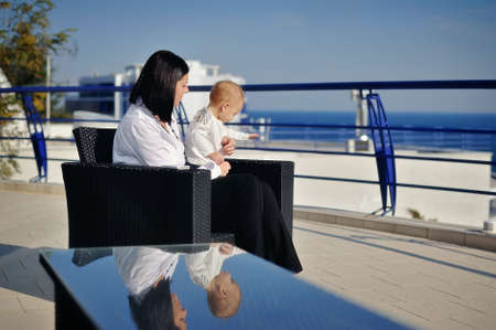 against the backdrop of sea and sky mom plays with her young sonの写真素材