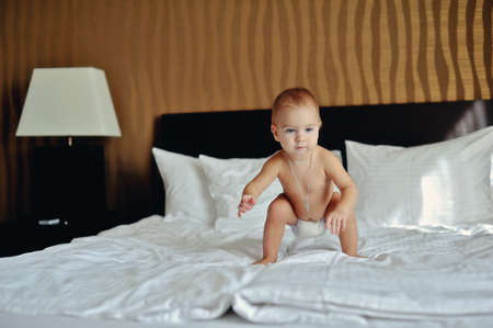 room on a white bed with red hair babe in diapersの写真素材