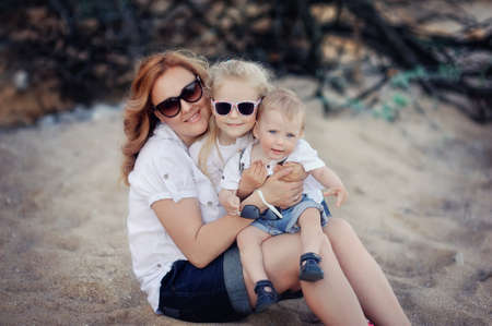 against the background of clay slopes mother and son have a rest on the shore of the seaの写真素材