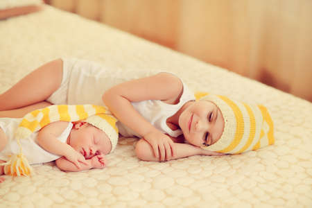 in bed sleeping baby in a blue cap with a large buboの写真素材