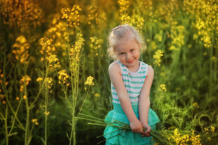 Cute girl with long hair on a meadow in spring dayの写真素材