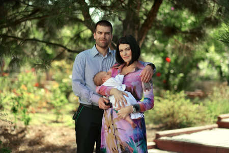 summer day on the nature of a young family with a babyの写真素材