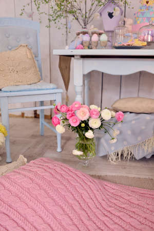 on the floor by the table a glass vase with a bouquet of pink ranunkulyusovの写真素材