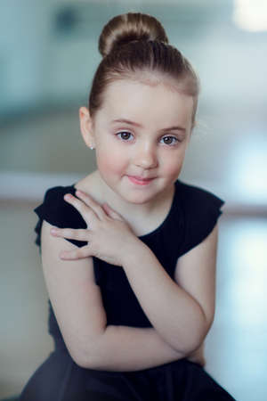 portrait of a little ballerina in a black dress with an elegant hairstyleの写真素材