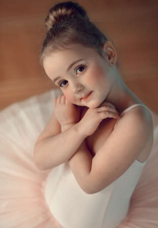 Portrait of a cute little ballerina in a white suitの写真素材