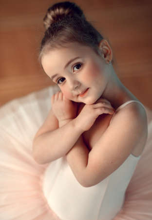 Portrait of a cute little ballerina in a white suitの写真素材