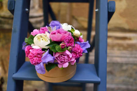 blue vase on the stairs with a beautiful bouquet of peonies and irisの写真素材