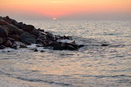 beautiful sunrise over the sea, surf and rock