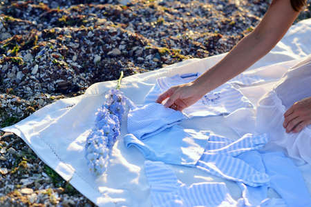 the sand blanket female hands and blue baby clothingの写真素材