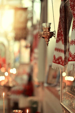 in the temple in the lights a candle at the icon on the chains hanging lampの写真素材