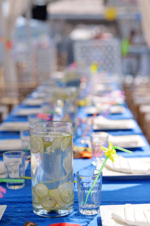 on banquet table large glass jug and glasses of lemonade with a strawの写真素材