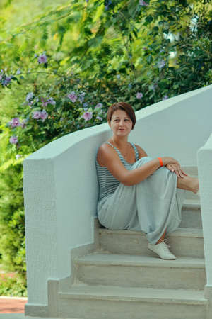He is sitting on the steps of a woman in a long dress with a hairstyleの写真素材