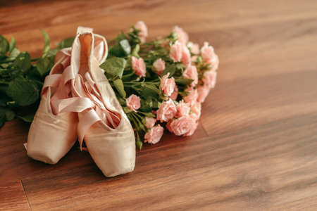 on wooden background big bouquet of pink roses and pointe shoesの写真素材