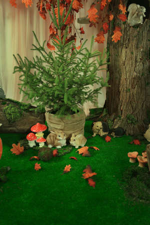 the fabulous scenery on the bright green grass mushrooms, under a tree, rabbits and hedgehogsの写真素材