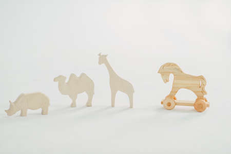 on a white background wooden toy horse on wheels and animalsの写真素材